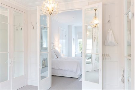 simsearch:649-06829416,k - White, luxury home showcase interior bedroom with French doors and chandelier Foto de stock - Sin royalties Premium, Código: 6113-09111881