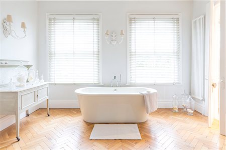 simsearch:6113-09111960,k - White, luxury home showcase bathroom with soaking tub and parquet hardwood floor Foto de stock - Sin royalties Premium, Código: 6113-09111892