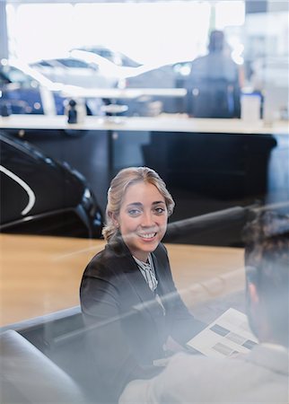 simsearch:6113-09059160,k - Portrait smiling car saleswoman working in car dealership showroom Photographie de stock - Premium Libres de Droits, Code: 6113-09111837