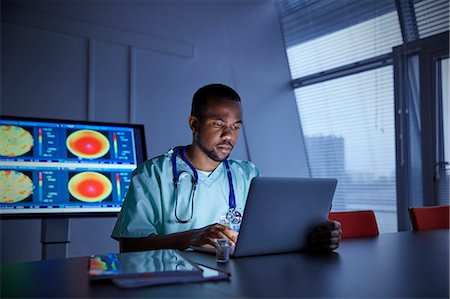 Focused male surgeon working at laptop in hospital Foto de stock - Sin royalties Premium, Código: 6113-09111920