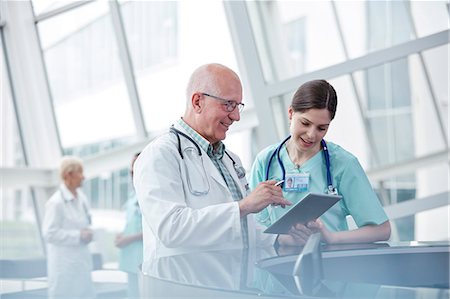 smiling doctor with lab coat - Doctor and nurse with digital tablet talking in hospital Stock Photo - Premium Royalty-Free, Code: 6113-09111937