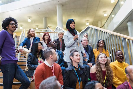 simsearch:6113-06497938,k - Smiling woman in hijab talking with microphone in conference audience Foto de stock - Sin royalties Premium, Código: 6113-09131145