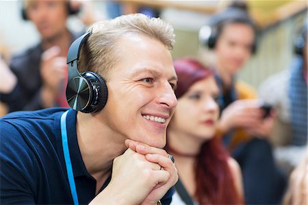 simsearch:6113-09131163,k - Smiling businessman with headphones listening in conference audience Photographie de stock - Premium Libres de Droits, Code: 6113-09131150