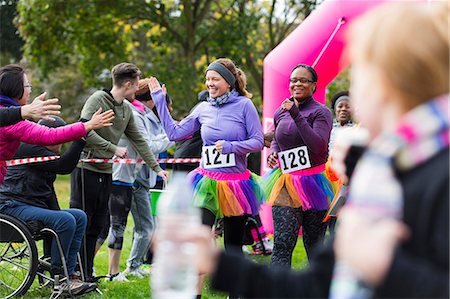 simsearch:6113-09131378,k - Female runners high-fiving spectators at charity run finish line Fotografie stock - Premium Royalty-Free, Codice: 6113-09131291