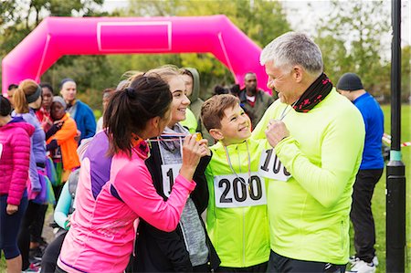 partnership community - Happy family with medals finishing charity run, celebrating Stock Photo - Premium Royalty-Free, Code: 6113-09131201