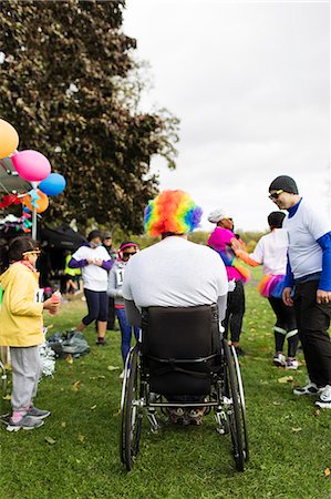 simsearch:6113-09131191,k - Man in wheelchair wearing clown wig at charity race in park Stockbilder - Premium RF Lizenzfrei, Bildnummer: 6113-09131204
