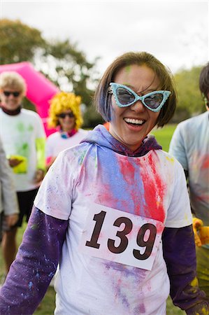 Portrait playful female runner in sunglasses and holi powder at charity run in park Stock Photo - Premium Royalty-Free, Code: 6113-09131233