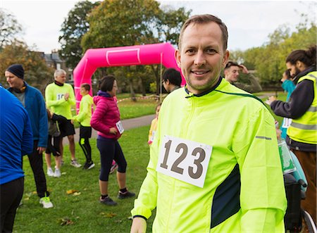 runners crossing the finish line - Portrait confident male runner at charity run in park Stock Photo - Premium Royalty-Free, Code: 6113-09131232