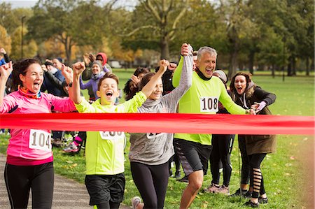 simsearch:6122-07699287,k - Enthusiastic family running, nearing charity run finish line Stock Photo - Premium Royalty-Free, Code: 6113-09131239