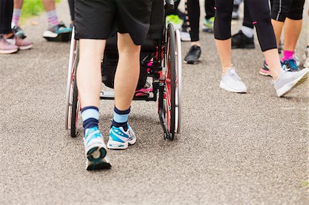 simsearch:695-03375151,k - Man pushing wheelchair on crowded path Photographie de stock - Premium Libres de Droits, Code: 6113-09131343