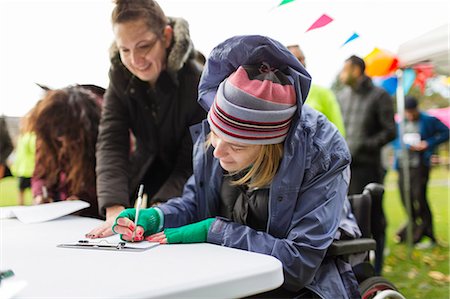 disability, adult, - Woman in wheelchair checking in at charity race Stock Photo - Premium Royalty-Free, Code: 6113-09131353