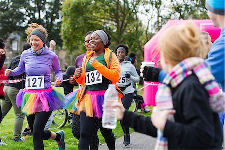 simsearch:6113-09131378,k - Female runners in tutus running at charity race in park Fotografie stock - Premium Royalty-Free, Codice: 6113-09131356