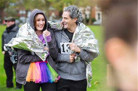 simsearch:6113-09168365,k - Happy couple runners wrapped in thermal blanket at charity run in park Foto de stock - Royalty Free Premium, Número: 6113-09131303