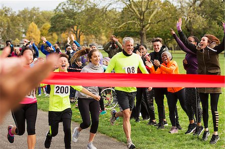 parents clap - Enthusiastic family running, nearing charity run finish line in park Stock Photo - Premium Royalty-Free, Code: 6113-09131336