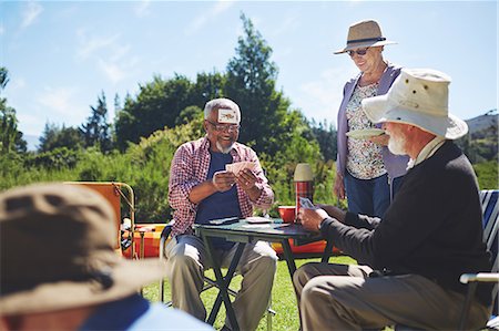 simsearch:6122-07697873,k - Playful active senior friends playing cards at sunny summer campsite Stock Photo - Premium Royalty-Free, Code: 6113-09131494