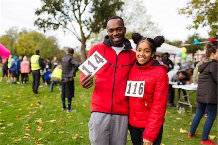 simsearch:6113-09131333,k - Portrait smiling, confident father and daughter runners with marathon bibs at charity run in park Photographie de stock - Premium Libres de Droits, Code: 6113-09131404