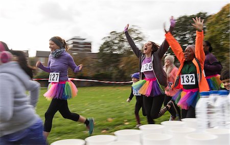 simsearch:6113-09131416,k - Enthusiastic female runners in tutus cheering, running at charity race in park Photographie de stock - Premium Libres de Droits, Code: 6113-09131424