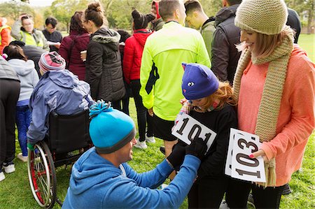 partnership community - Father runner pinning marathon bib on daughter at charity run in park Stock Photo - Premium Royalty-Free, Code: 6113-09131429