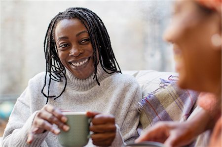 simsearch:6113-09131598,k - Enthusiastic, smiling woman listening to friend and drinking coffee Photographie de stock - Premium Libres de Droits, Code: 6113-09131552