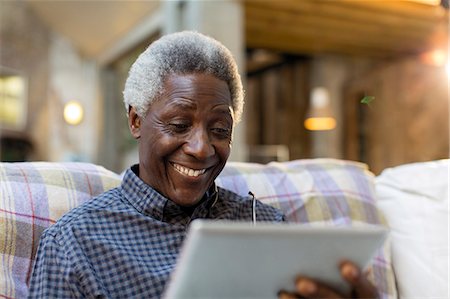 simsearch:6124-09143740,k - Smiling senior man using digital tablet on sofa Stock Photo - Premium Royalty-Free, Code: 6113-09131554