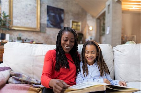 simsearch:6113-07731296,k - Mother and daughter looking at photo album on sofa Stock Photo - Premium Royalty-Free, Code: 6113-09131558