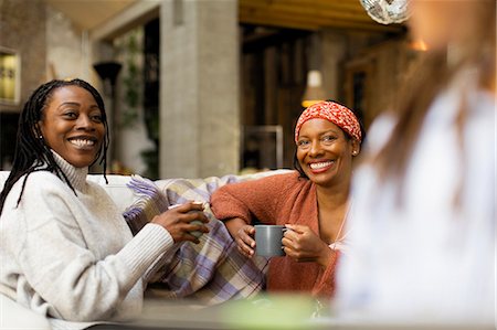 simsearch:6113-07146829,k - Smiling women talking and drinking coffee on sofa Foto de stock - Sin royalties Premium, Código: 6113-09131583