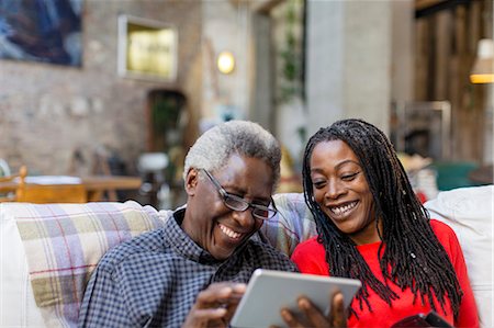 simsearch:649-07118937,k - Adult daughter teaching senior father how to use digital tablet on sofa Stock Photo - Premium Royalty-Free, Code: 6113-09131597