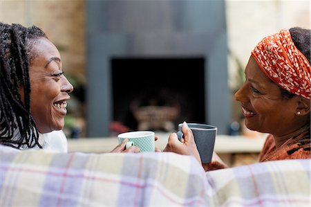 simsearch:6113-07146829,k - Smiling women friends talking and drinking tea on sofa Foto de stock - Sin royalties Premium, Código: 6113-09131594