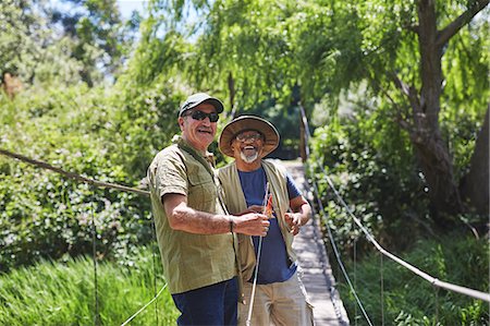 flyfishing sunlight - Portrait happy active senior men friends fishing on sunny summer footbridge Stock Photo - Premium Royalty-Free, Code: 6113-09131508