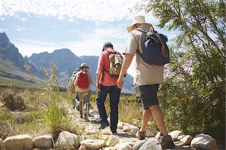 simsearch:6113-08743406,k - Active senior friends with backpacks hiking along sunny summer footpath Foto de stock - Sin royalties Premium, Código: 6113-09131516