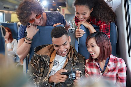 simsearch:6113-08805296,k - Young friends looking at photos on digital camera on passenger train Foto de stock - Sin royalties Premium, Código: 6113-09131645