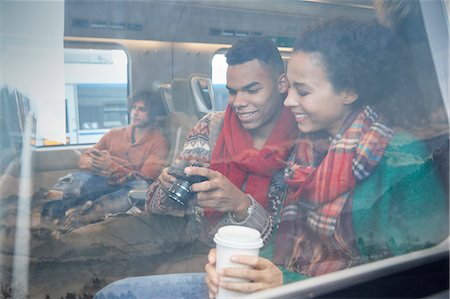 simsearch:6113-09131654,k - Young couple with coffee looking at digital camera at window on passenger train Stockbilder - Premium RF Lizenzfrei, Bildnummer: 6113-09131663