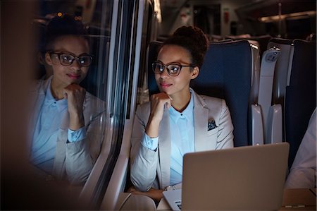 rail transport - Confident, thoughtful businesswoman looking out window on passenger train at night, working at laptop Stock Photo - Premium Royalty-Free, Code: 6113-09131677