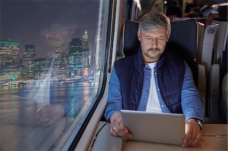 see city - Man using digital tablet on passenger train at night Stock Photo - Premium Royalty-Free, Code: 6113-09131601