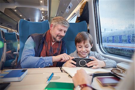 Father and son using smart phone on passenger train Foto de stock - Sin royalties Premium, Código: 6113-09131610