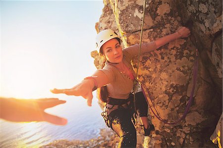 simsearch:6122-07704531,k - Female rock climber reaching for helping hand Foto de stock - Sin royalties Premium, Código: 6113-09131741