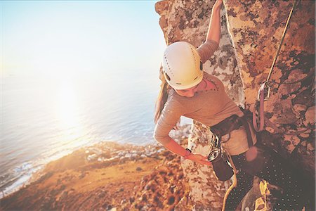 escalar - Female rock climber reaching for clip above sunny ocean Photographie de stock - Premium Libres de Droits, Code: 6113-09131773