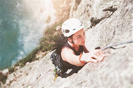 Focused, determined female rock climber scaling rock Photographie de stock - Premium Libres de Droits, Code: 6113-09131776