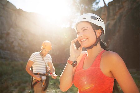 sport woman with helmet - Smiling female rock climber talking on smart phone Stock Photo - Premium Royalty-Free, Code: 6113-09131781