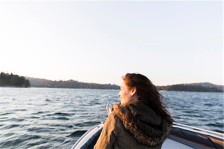 serene lake boat - Smiling woman boating on sunny, tranquil lake Stock Photo - Premium Royalty-Free, Code: 6113-09131701