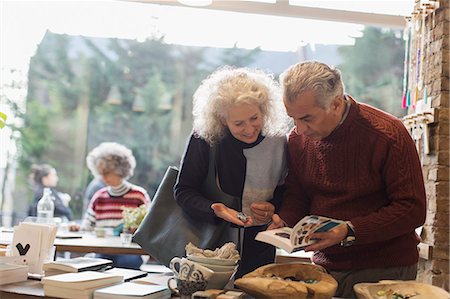 senior woman smiling - Senior couple looking at book in shop Stock Photo - Premium Royalty-Free, Code: 6113-09131722