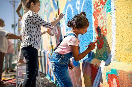 simsearch:6113-09240183,k - Girl volunteer painting vibrant mural on sunny wall Fotografie stock - Premium Royalty-Free, Codice: 6113-09240177