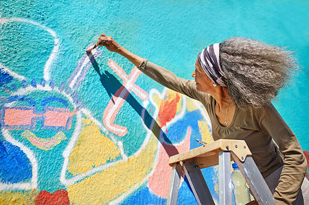 simsearch:6113-09240186,k - Senior woman painting vibrant mural on sunny wall Fotografie stock - Premium Royalty-Free, Codice: 6113-09240175