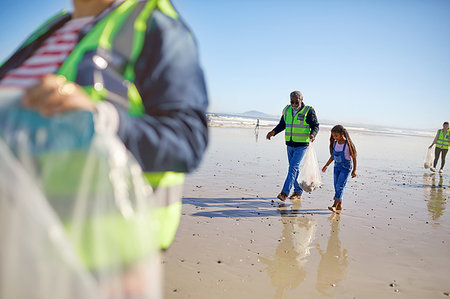 simsearch:649-02290472,k - Grandfather and granddaughter volunteers cleaning up litter on sunny wet sand beach Stock Photo - Premium Royalty-Free, Code: 6113-09240193