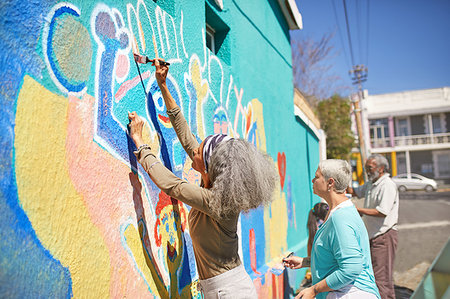 simsearch:6113-09240186,k - Senior community volunteers painting vibrant mural on sunny urban wall Fotografie stock - Premium Royalty-Free, Codice: 6113-09240194