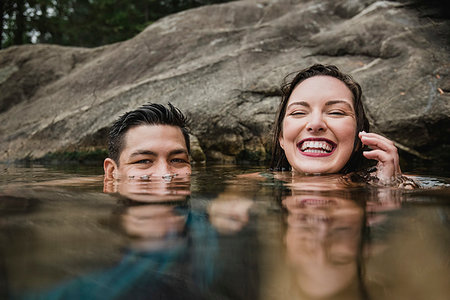 simsearch:6113-09199766,k - Portrait playful young couple swimming in lake Fotografie stock - Premium Royalty-Free, Codice: 6113-09240136