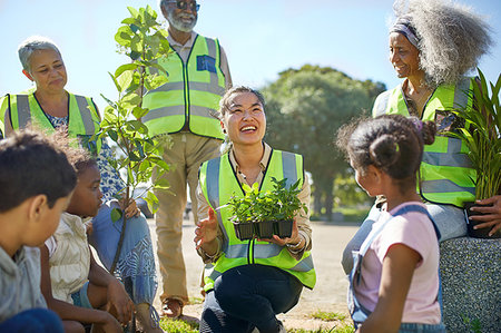 Happy volunteers planting trees and plants in sunny park Photographie de stock - Premium Libres de Droits, Code: 6113-09240255