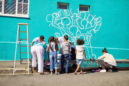 simsearch:6113-09240262,k - Kid volunteers painting community mural on sunny wall Foto de stock - Royalty Free Premium, Número: 6113-09240264