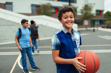 Portrait smiling, confident tween boy playing basketball in schoolyard Stock Photo - Premium Royalty-Free, Code: 6113-09240296