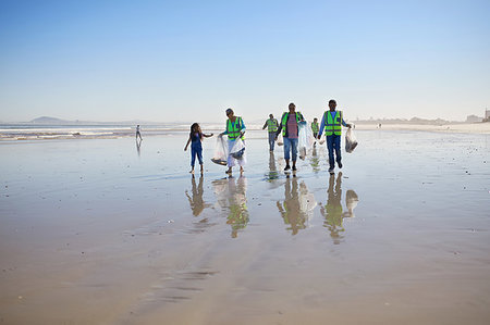 simsearch:649-02290472,k - Volunteers cleaning up litter on sunny wet sand beach Stock Photo - Premium Royalty-Free, Code: 6113-09240210